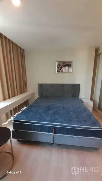 Condominium for rent - Master bedroom with large upholstered bed and wood floors
