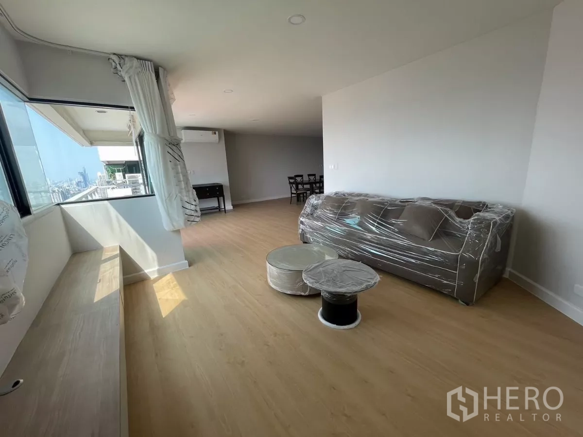 公寓 出租在Sathon, Bangkok - 采光充足的客厅，转角窗、飘窗座与包膜沙发