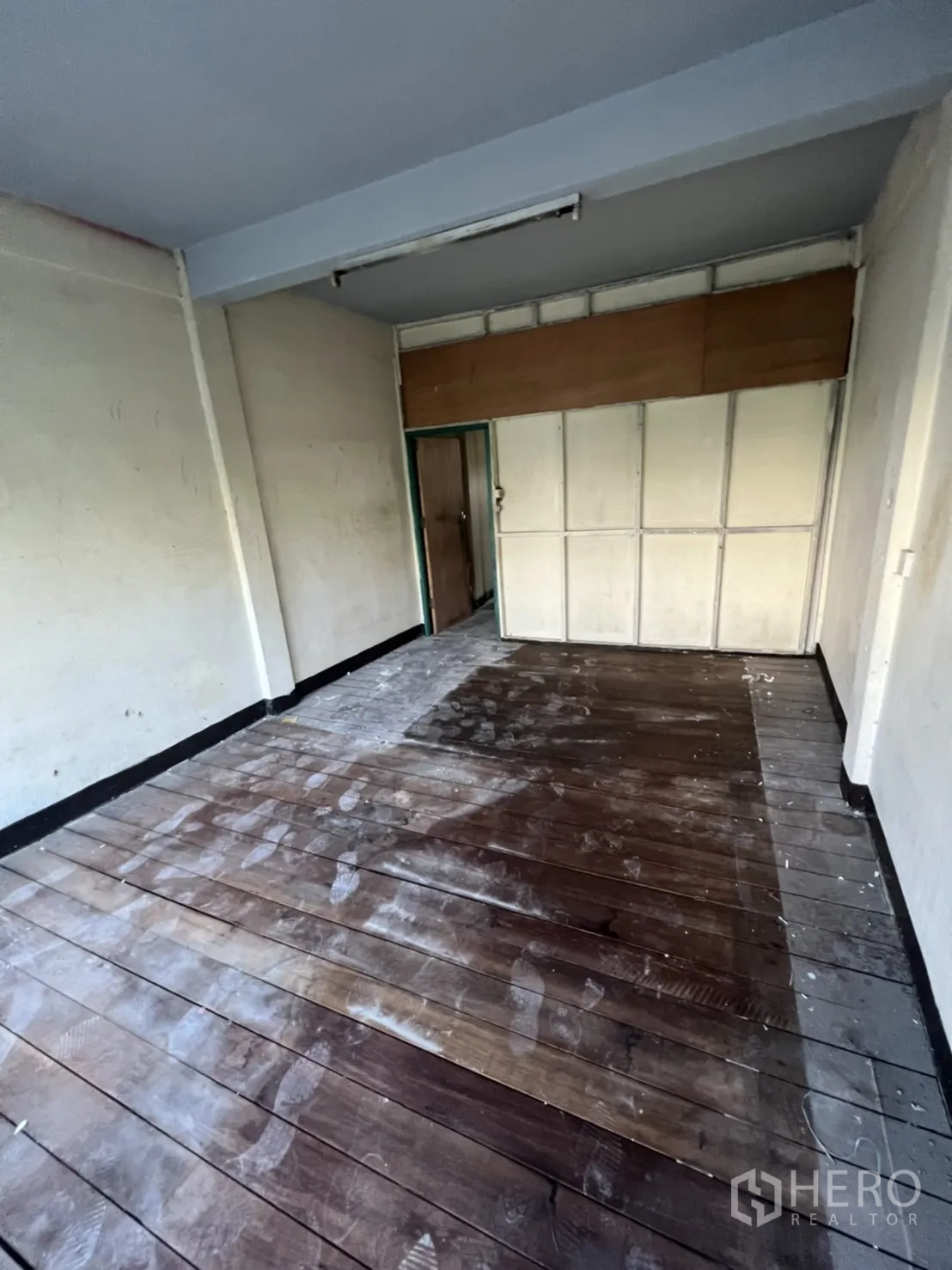 店屋 出租在Watthana, Bangkok - 空置房间，木板地与日光灯，墙面简洁，布局灵活。