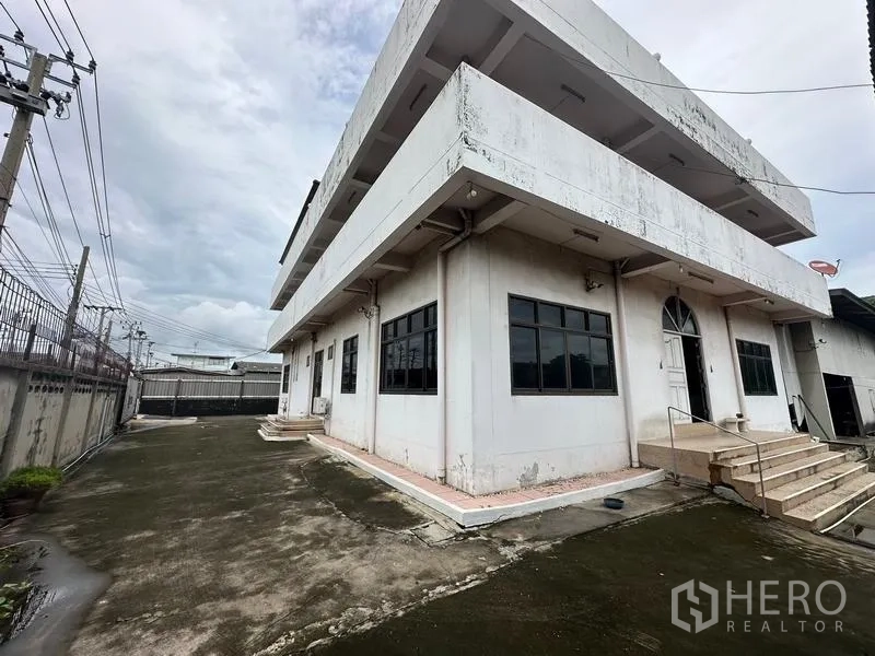 Home Office for sale in Phra Pradaeng, Samut Prakan - Side exterior showing steps and a wide driveway suitable for parking.