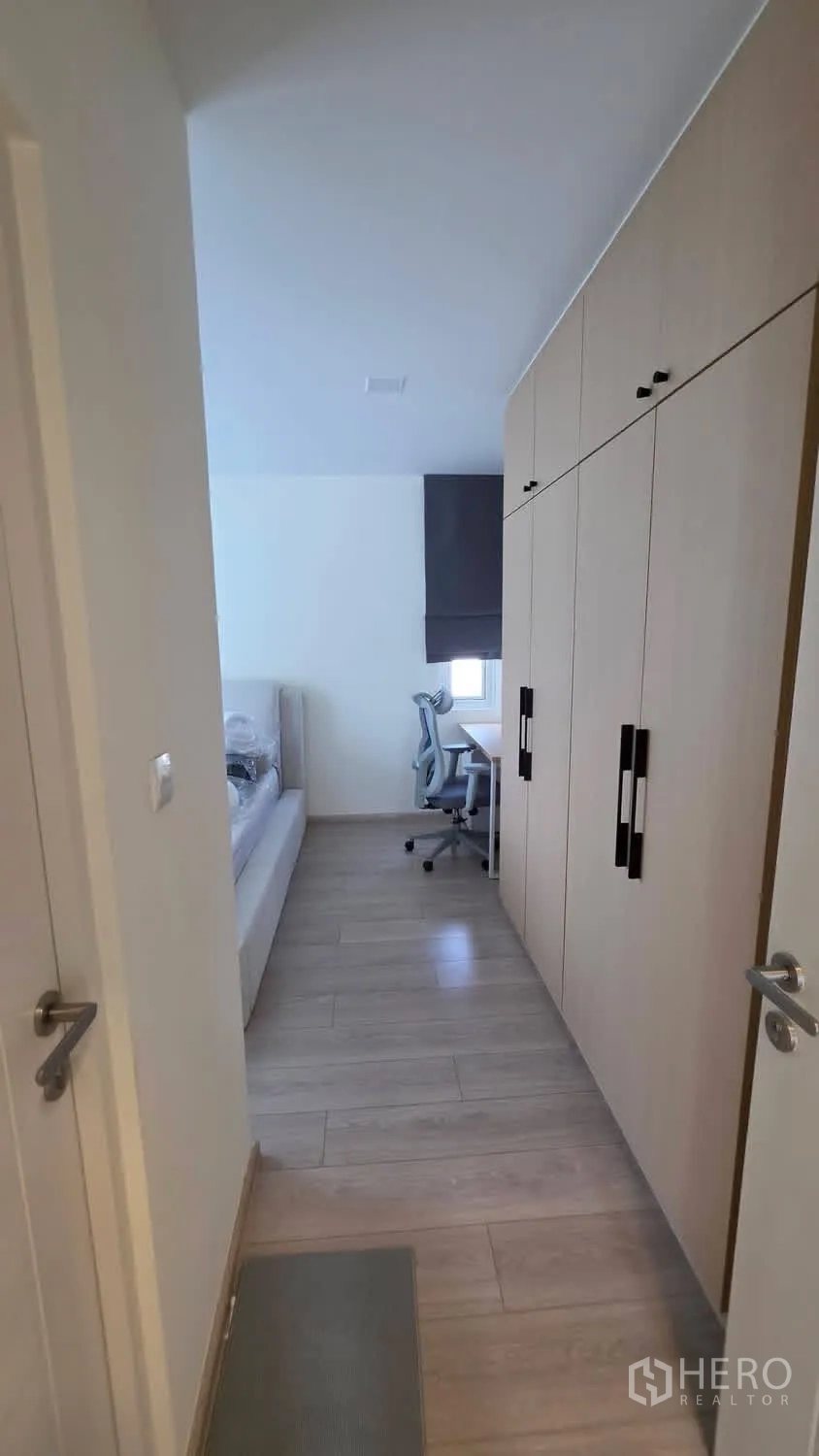 Detached House for rent in Bang Phli, Samut Prakan - Walk-through wardrobe corridor with extensive cabinets leading to bedroom.