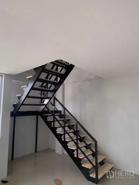 Warehouse for rent in Bang Phli, Samut Prakan - Industrial interior showing a black steel staircase leading to the mezzanine office.