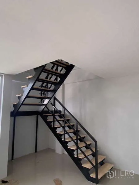 Warehouse for rent in Bang Phli, Samut Prakan - Industrial interior showing a black steel staircase leading to the mezzanine office.