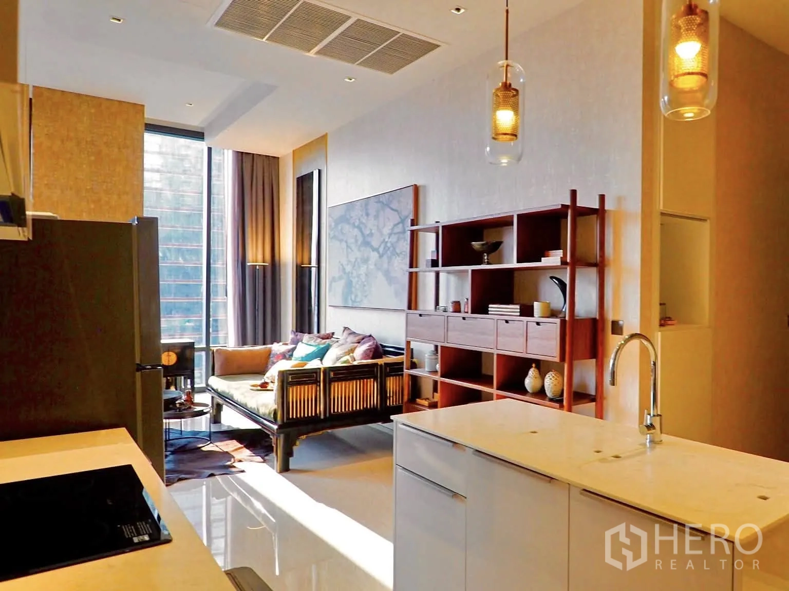 Condominium for rent in Bang Rak, Bangkok - Open-plan kitchen with island and pendant lights facing living area.