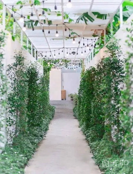 พื้นที่ขายปลีก ให้เช่าในSuan Luang, Bangkok - ทางเดินมีหลังคา ประดับไฟสตริง สองข้างเป็นแนวพุ่มไม้ นำสู่ทางเข้าพื้นที่ค้าปลีก