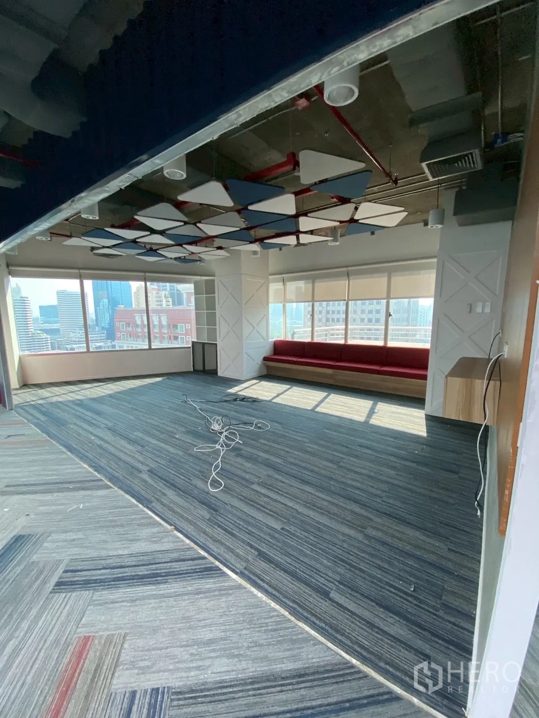 办公室 for rent in Watthana, Bangkok - 休闲区设窗边长座，城市景观与吸音吊顶。