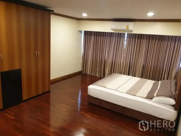 คอนโด ให้เช่าในWatthana, Bangkok - ห้องนอนมีหน้าต่างกว้าง ม่านทึบ แอร์แยก และตู้เสื้อผ้าบนพื้นไม้เงา