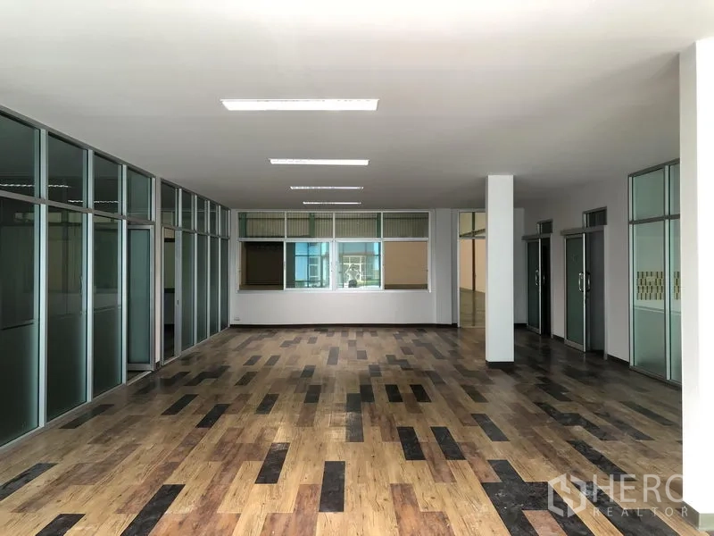 Factory for rent in Samut Prakan - Bright office floor with multiple glass‑partitioned rooms and ceiling lights.