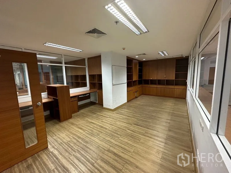 Office Space for rent or sale - Multipurpose room with wood flooring and extensive built-in cabinets.