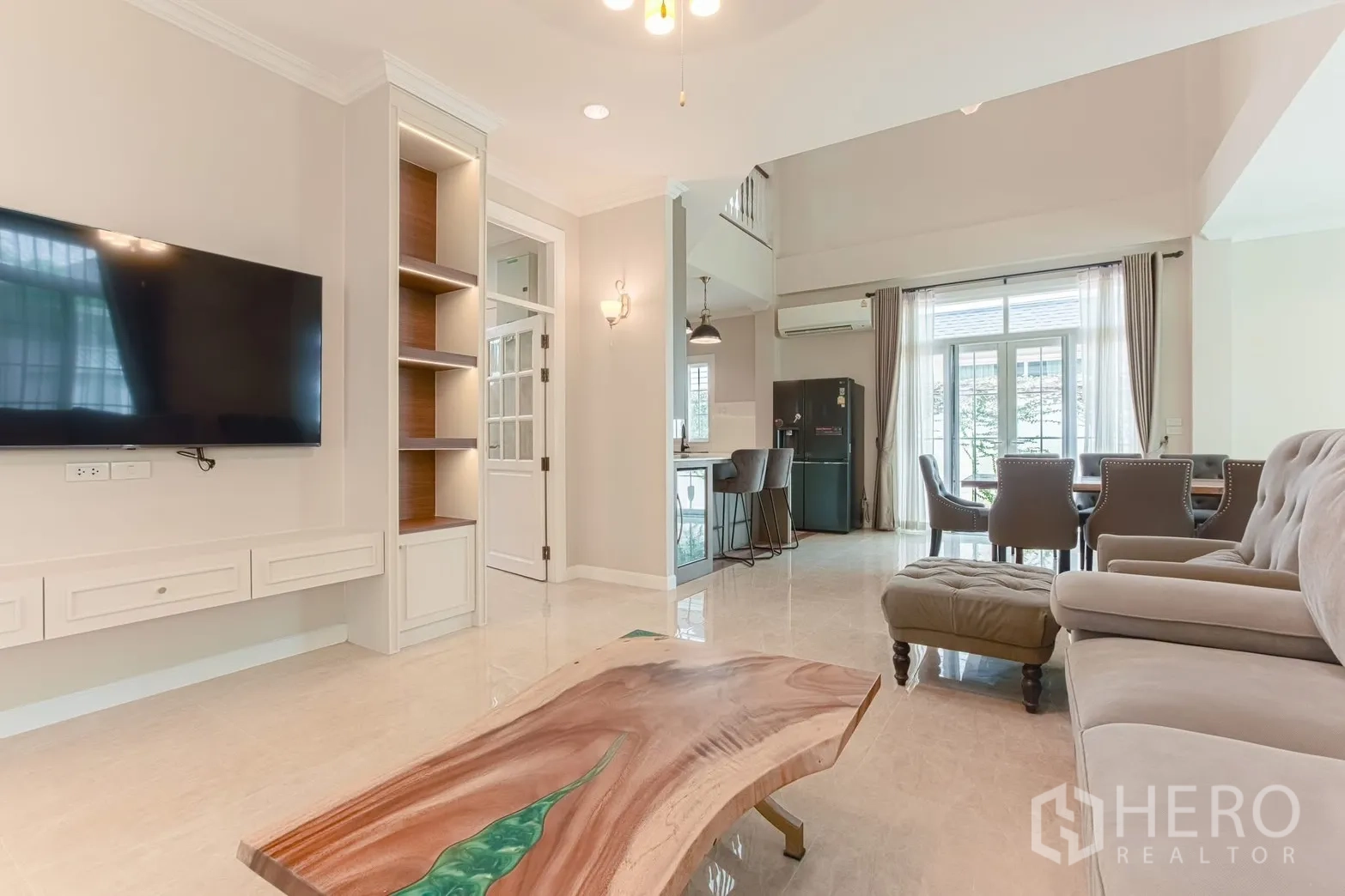 Detached House for rent in Bang Na, Bangkok - TV wall and coffee table looking toward the dining and kitchen areas.