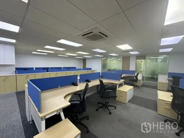 Office Space for rent - Curved shared desks with task chairs, cassette air-conditioning and glass partitions in a modern workspace.