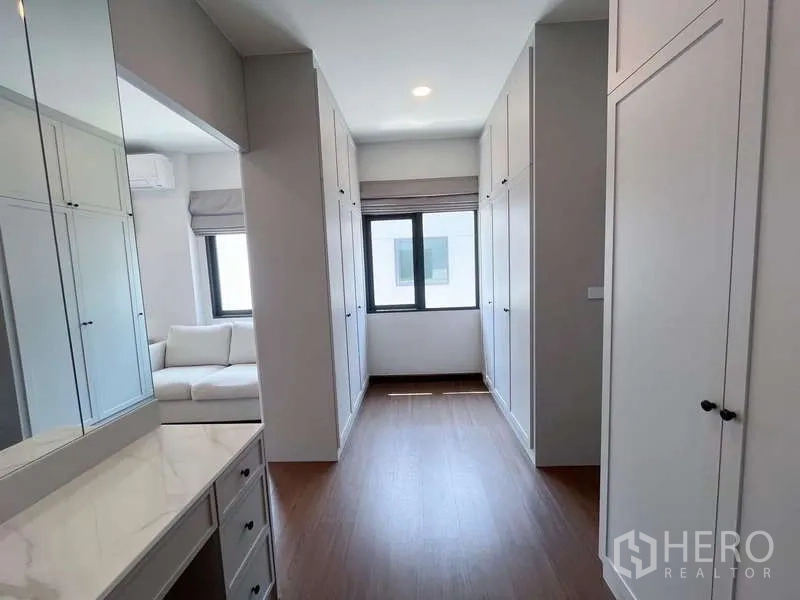 Detached House for rent or sale in Bang Phli, Samut Prakan - Walk-in closet corridor with built-in cabinetry and dressing table.