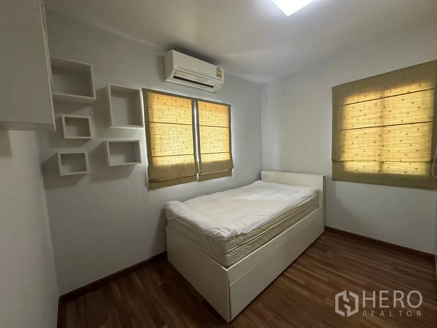 บ้าน ให้เช่า - ห้องนอนแขกเตียงพร้อมชั้นวางและหน้าต่างสองบานมีม่าน