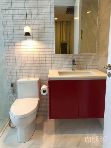 Condominium for sale in Watthana, Bangkok - Second bathroom featuring a red vanity, toilet and tiled walls.