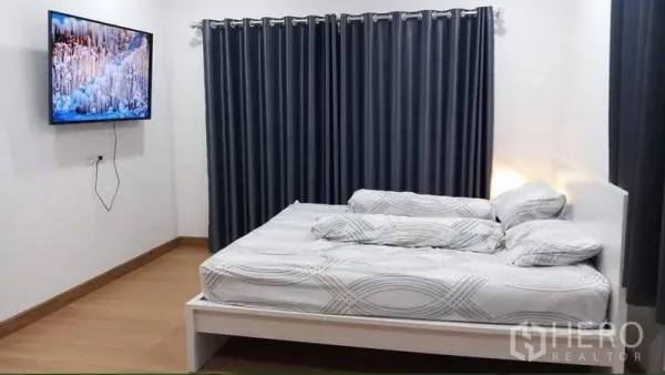 บ้าน ให้เช่าหรือขายในPrawet, Bangkok - ห้องนอนสว่าง เตียงสีขาว ทีวีติดผนัง ม่านทึบสีเข้ม