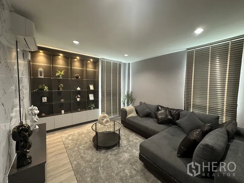 Factory for sale in Lam Luk Ka, Pathum Thani - Private lounge with sectional sofa, display shelves and blinds.