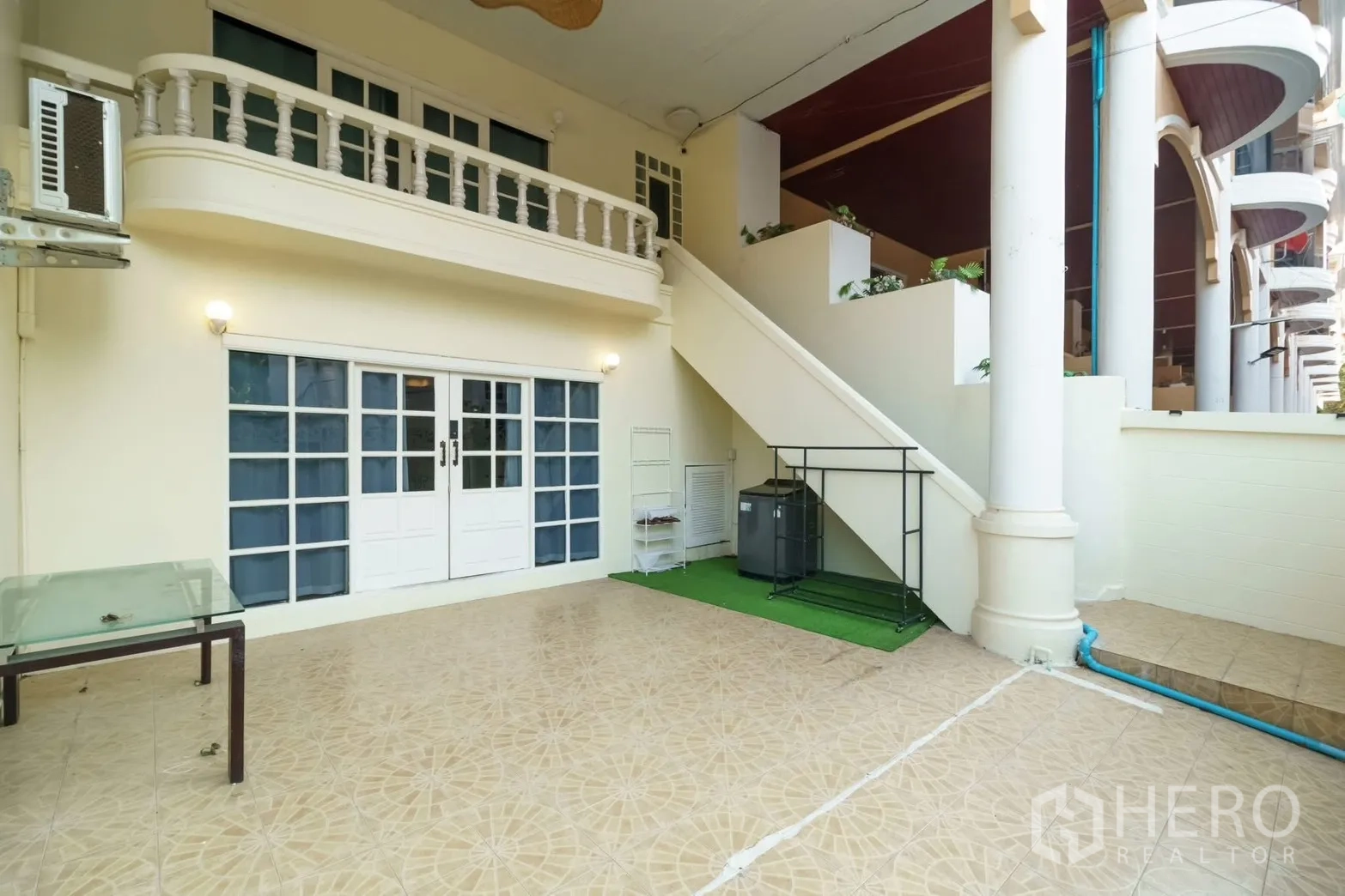 联排别墅 for rent in Watthana, Bangkok - 一层室外露台，法式玻璃门与外部楼梯、柱廊。