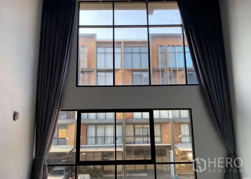 Home Office for rent or sale - Two-story front glazing with dark curtains overlooking neighboring townhomes.