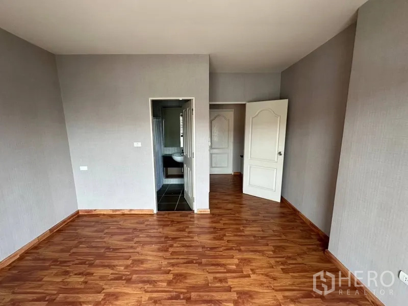 ทาวน์เฮาส์ ให้เช่าหรือขายในPhra Khanong, Bangkok - ห้องนอนพื้นไม้ โทนสีเรียบ พร้อมประตูเชื่อมเข้าห้องน้ำ