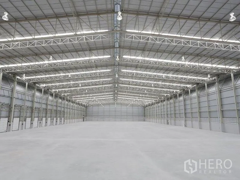 Factory for rent in Bang Pakong, Chachoengsao - High-clearance warehouse interior with steel truss roof and polished concrete floor.