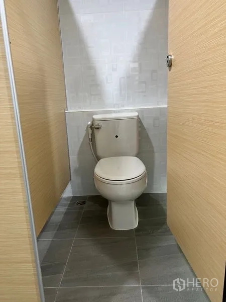 Warehouse for rent in Bang Phli, Samut Prakan - Clean toilet cubicle with ceramic tiles inside the facility