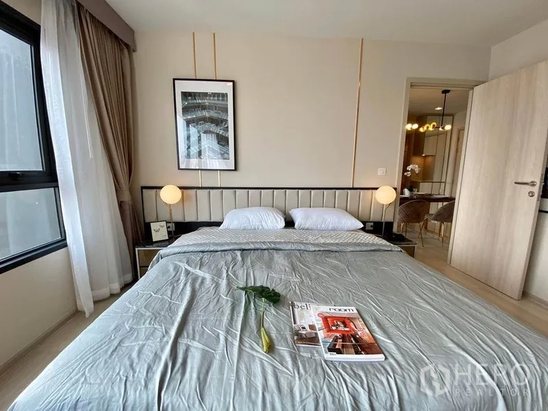 公寓 出租在Pathum Wan, Bangkok - 主卧特写：软包床头、墙面装饰画与暖色灯光。