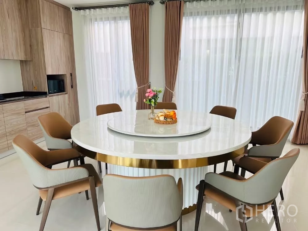 บ้าน ให้เช่าหรือขายในBang Kapi, Bangkok - ห้องทานอาหาร โต๊ะกลมใหญ่ 8 ที่นั่ง ใกล้หน้าต่างบานใหญ่และครัวบิลท์อิน