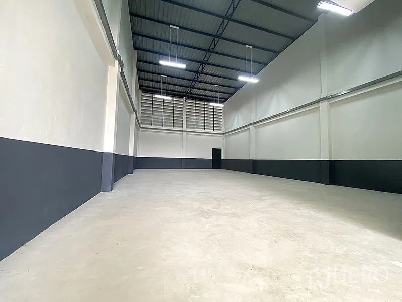 货栈 出租在Mueang Pathum Thani, Pathum Thani - 挑高仓储大厅，混凝土地面，通风窗与LED照明。