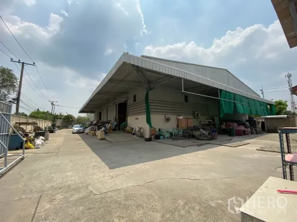 Factory for sale in Khlong Luang, Pathum Thani - Metal-clad factory with a wide covered loading bay and large concrete yard in Khlong Luang.