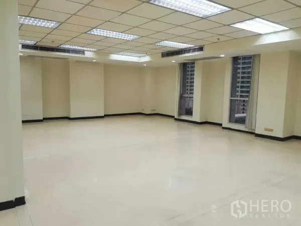 สำนักงาน ให้เช่าในRatchathewi, Bangkok - ห้องสำนักงานแบบเปิดโล่งสว่าง ฝ้าเพดานกริด ไฟฟลูออเรสเซนต์ ผนังโทนกลาง และหน้าต่างสูง