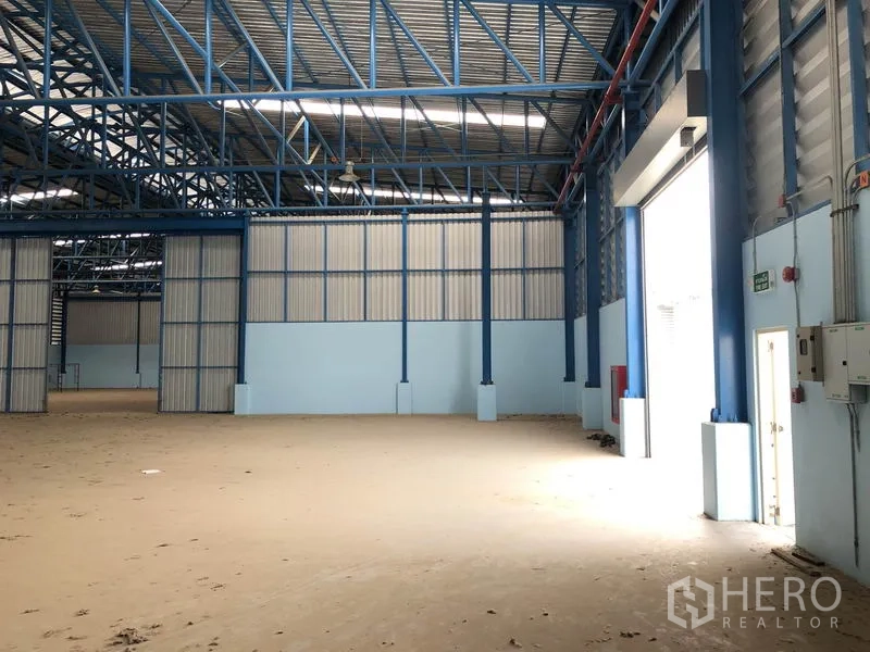 Warehouse for rent in Samut Prakan - Loading zone inside the warehouse with high roller shutter door allowing vehicle entry.