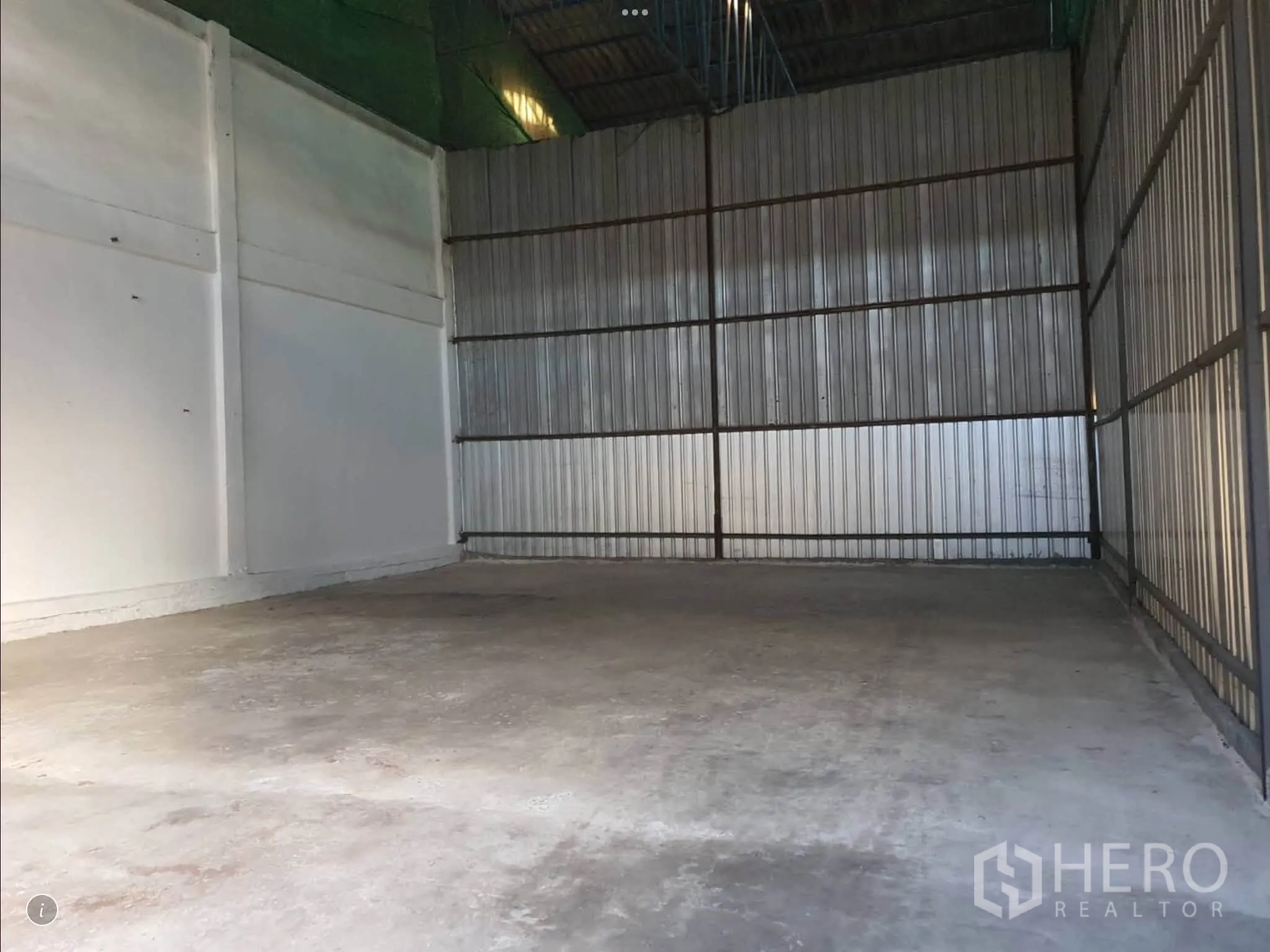 Warehouse for rent in Bang Phli, Samut Prakan - Empty storage area featuring a concrete floor and corrugated metal walls.