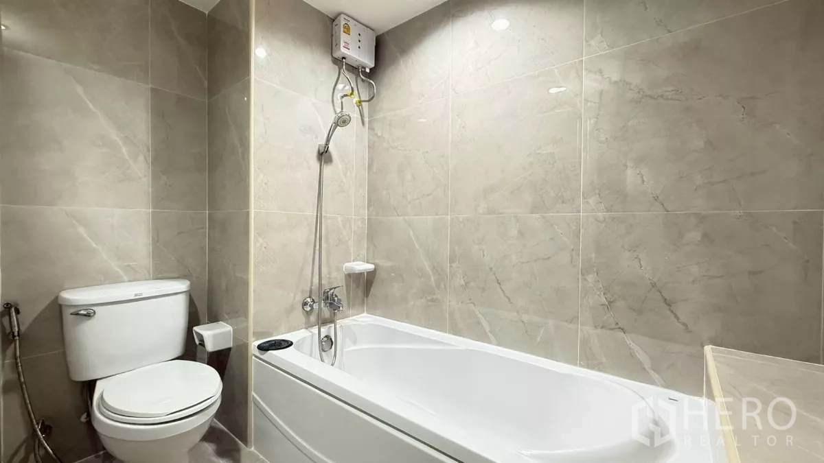 คอนโด ขายในYan Nawa, Bangkok - ห้องน้ำปูกระเบื้องลายหินอ่อน พร้อมอ่างอาบน้ำและชุดฝักบัว