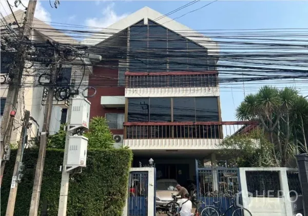 บ้าน ขายในSuan Luang, Bangkok - มุมมองด้านหน้าบ้านเดี่ยว หน้าต่างกระจกกว้าง ระเบียง และประตูรั้วสีน้ำเงิน