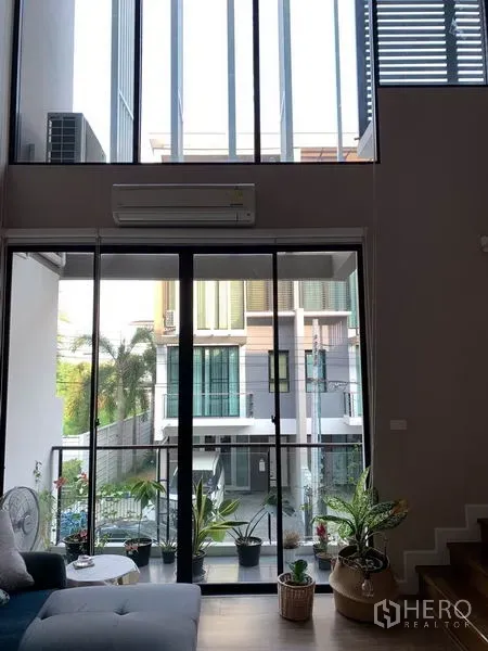 ทาวน์เฮาส์ ให้เช่าในKhlong Toei, Bangkok - ห้องนั่งเล่นเพดานสูงสองชั้น พร้อมกระจกเต็มผนังและวิวระเบียง