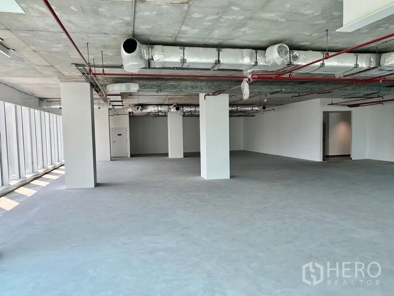 Office Space for rent in Sathon, Bangkok - Open-plan 219 sqm office shell with exposed ceiling ducts, sprinkler lines, columns and full-height windows in Sathon.