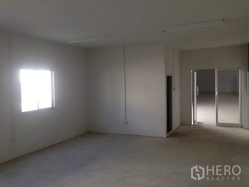 Warehouse for rent in Bang Bua Thong, Nonthaburi - Internal office room with window and sliding glass door inside the warehouse unit.