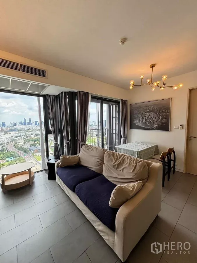 คอนโด ให้เช่าหรือขายในPhaya Thai, Bangkok - ห้องนั่งเล่นสว่างด้วยกระจกเต็มบาน มีโซฟา ชุดทานอาหาร โคมแชนเดอเลียร์ และระเบียงชมวิวเมืองกรุงเทพฯ
