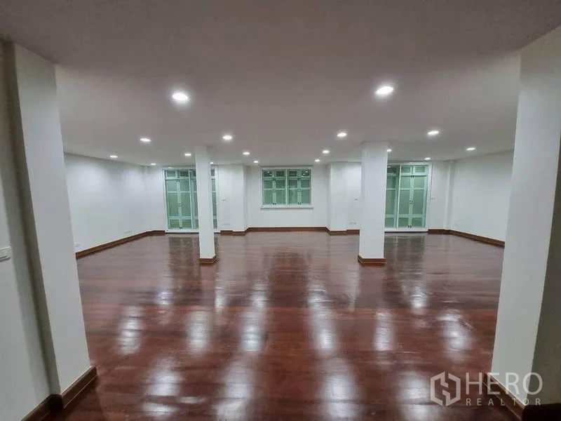 อาคารพาณิชย์ ให้เช่าในBang Rak, Bangkok - พื้นที่โล่งกว้างพื้นไม้สีเข้ม ผนังสีขาว ไฟดาวน์ไลท์ พร้อมเสากลางและหน้าต่าง