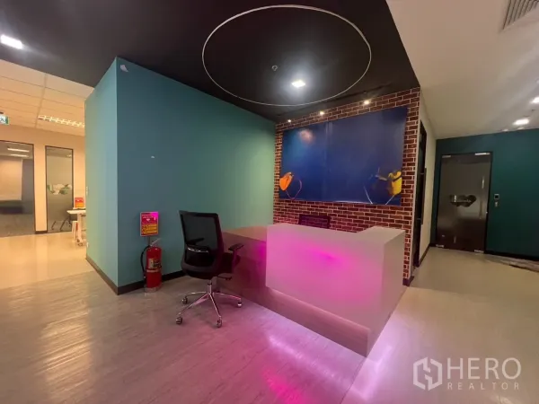 Office Space for rent in Huai Khwang, Bangkok - Modern office reception with an illuminated front desk, brick accent wall and glass entry in Huai Khwang, Bangkok.