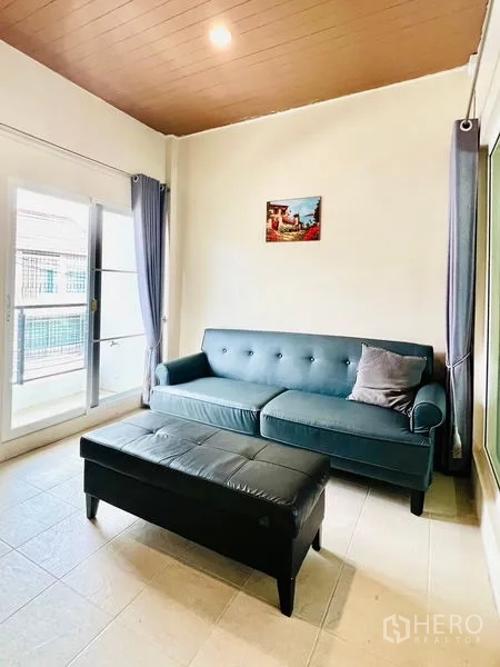 联排别墅 出租在Prawet, Bangkok - 小客厅，沙发与脚踏，可通阳台