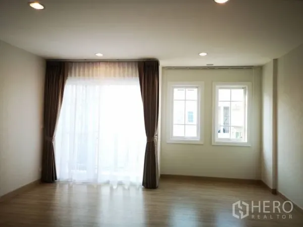 ทาวน์เฮาส์ ให้เช่าในBang Na, Bangkok - ห้องนอนชั้นบนสว่าง ไฟดาวน์ไลท์ มีหน้าต่างสองบานและทางออกระเบียง