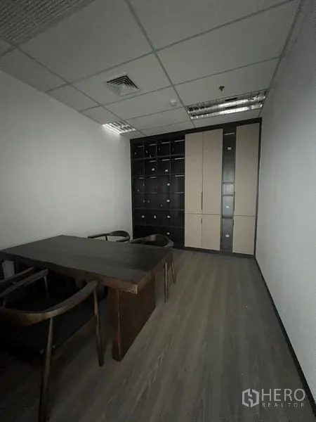 Office Space for rent in Huai Khwang, Bangkok - Compact meeting room with dark wood table and a full wall of storage cabinets.