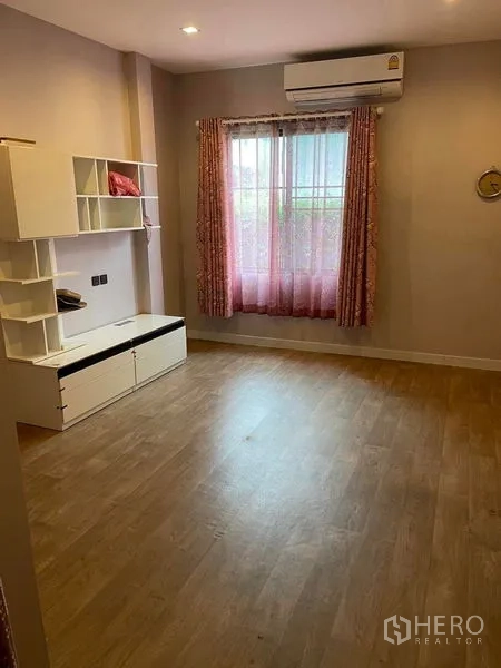 Detached House for sale in Mueang Samut Prakan, Samut Prakan - Cozy bedroom with window, air conditioner and built-in storage shelves.