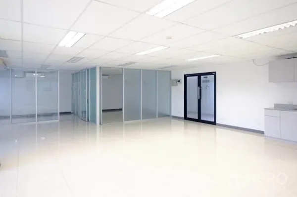 办公空间 出租在Chatuchak, Bangkok - 宽敞办公区，玻璃隔断房间、黑框玻璃门与一侧茶水间。