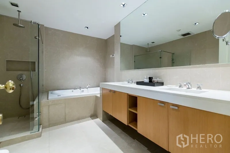 Condominium for rent in Pathum Wan, Bangkok - Spacious bathroom with glass shower, bathtub, and double vanity.