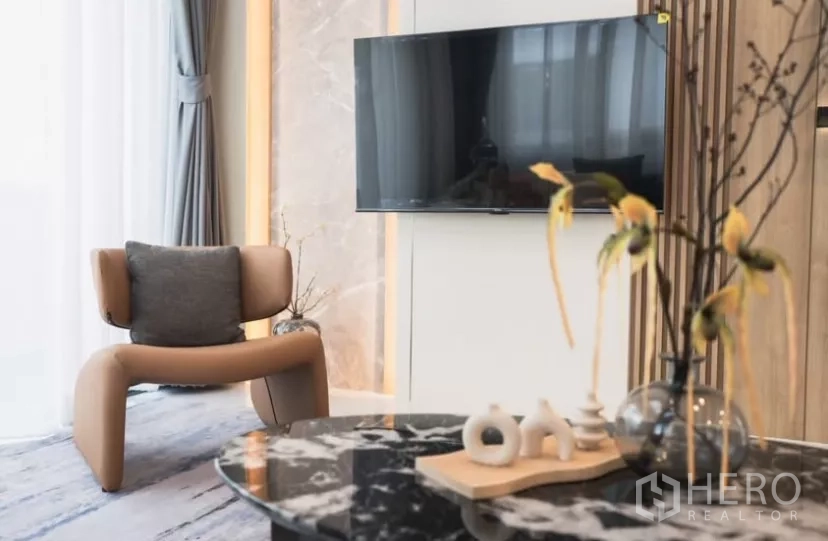 Detached House for rent in Bang Phli, Samut Prakan - Cozy living corner with wall-mounted TV, designer chair and marble coffee table.