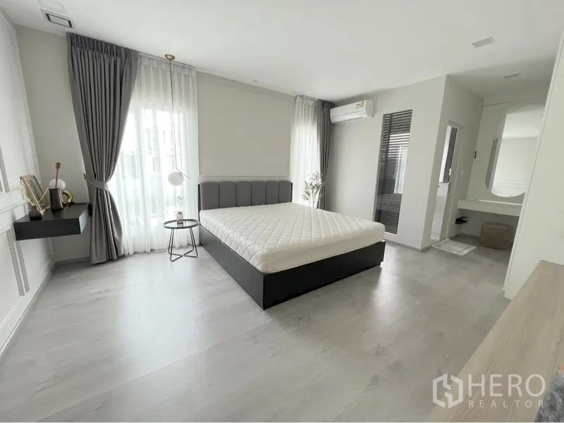 Detached House for rent or sale in Prawet, Bangkok - Spacious master bedroom with large windows and ensuite vanity area.