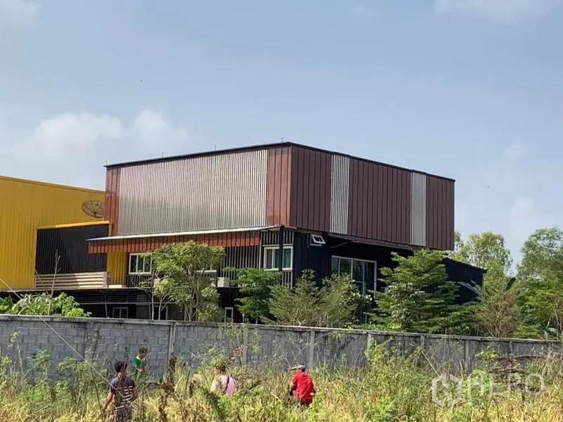 โรงงาน ขายในThanyaburi, Pathum Thani - อาคารสำนักงานสองชั้นกรุเมทัลชีท ข้างตัวโรงงาน รายล้อมด้วยต้นไม้และกำแพง