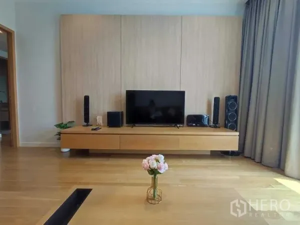 คอนโด ให้เช่าในKhlong Toei, Bangkok - ห้องนั่งเล่นสไตล์โมเดิร์น ชุดทีวีบิวท์อิน พื้นไม้ ผ้าม่านสูง และโต๊ะกลางดอกไม้